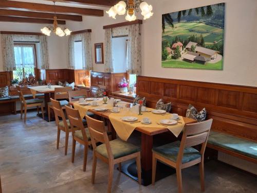 a dining room with a long table and chairs at Waldpension Ranner 