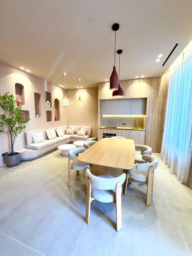 un salon avec une table et des chaises en bois dans l'établissement Appartement 3 chambres avec jardin privé, à Cannes