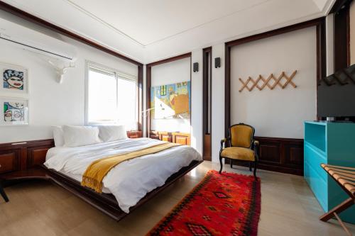 a bedroom with a bed and a tv and a chair at The Penthouse in Tel Aviv