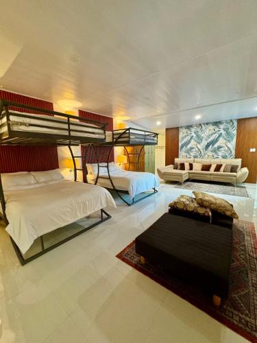 a bedroom with two bunk beds and a couch at Cozy Dorm type room in Malaybalay