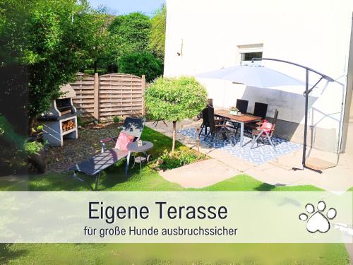 an image of a garden with an image of an orange fence at Ferienwohnung im Sauerland Hunde willkommen Kamin und Garten am Waldrand Muehls-Sauerland in Lennestadt