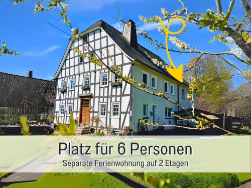 a house with a sign in front of it at Ferienwohnung im Sauerland Hunde willkommen Kamin und Garten am Waldrand Muehls-Sauerland in Lennestadt