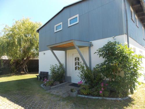 a house with a white door and some plants at Ferienwohnung Sonnenblume in Gerswalde