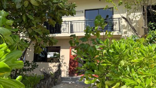 a building with a balcony and a red door at Belmar Beach in Bodufolhudhoo