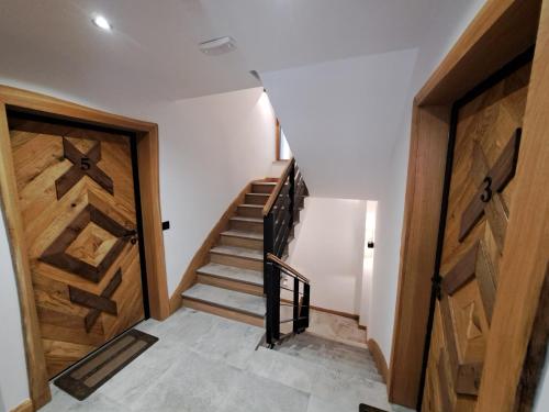 a hallway with a staircase and a wooden door at Kasa di legno apartman 3 in Kopaonik