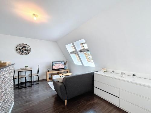 un salon avec un canapé et une télévision dans l'établissement Pleasant Studio, à Saint-Brieuc