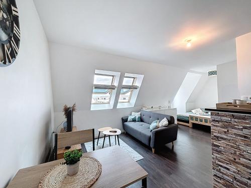 un salon avec un canapé et une table dans l'établissement Pleasant Studio, à Saint-Brieuc