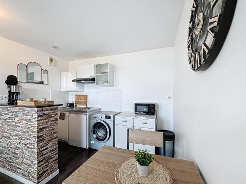 une cuisine avec lave-linge, sèche-linge et une table dans l'établissement Pleasant Studio, à Saint-Brieuc