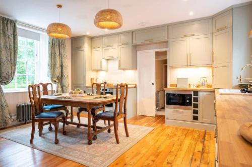 a kitchen and dining room with a table and chairs at Penninghame Estate - Earl's Library in Challoch
