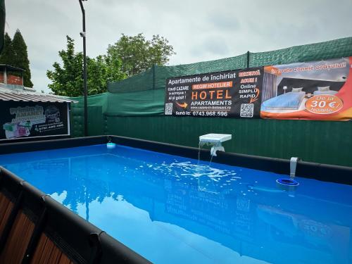 a swimming pool with a sign on the side of a building at Apartament cu 2 Dormitoare de lux situat in complex ApartHotel Botosani 4 in Botoşani