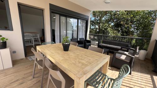 a wooden table and chairs on a balcony at Longanea 2 in Mon Caprice