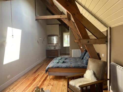 a room with a bed and a chair in it at Moulin de Maupoy in Saint-Symphorien-de-Marmagne