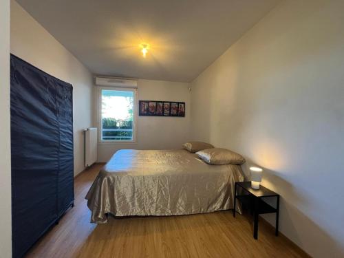 une chambre avec un lit et une fenêtre dans l'établissement T2 cosy et rénové avec terrasse - proche de Lyon, à Vaulx-en-Velin