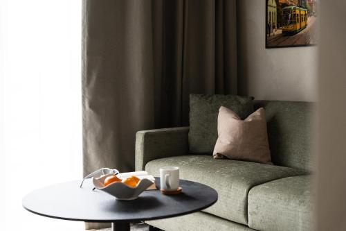 a living room with a green couch and a table at Vander Aparthotel Inre Hamnen in Norrköping