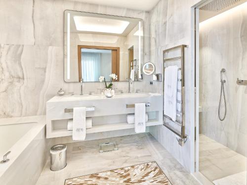 a bathroom with a sink and a tub and a mirror at La Réserve de Beaulieu in Beaulieu-sur-Mer