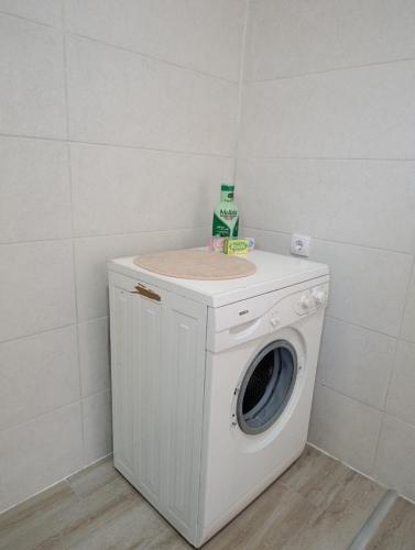 a washing machine with a bottle on top of it at Andjela LUX in Belgrade