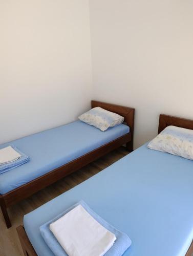 two beds in a room with blue sheets at Andjela LUX in Belgrade