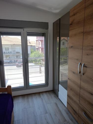 a room with two large windows and wooden cabinets at Andjela LUX in Belgrade