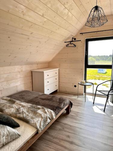 a bedroom with a bed and a window and a table at Zacisze Mrozy in Ełk