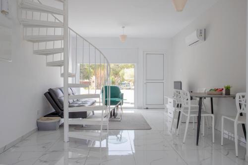 a white room with a staircase and a table and chairs at 2BD Garden Apartment in Paphos City