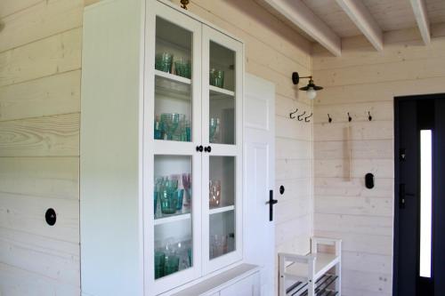 a room with a white cabinet with glasses in it at Zacisze Mrozy in Ełk