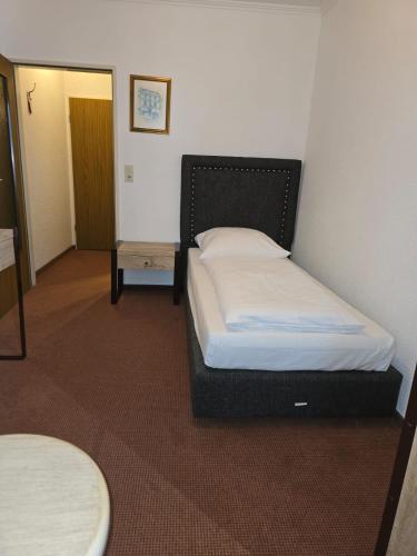 a bedroom with a bed in a room with a table at Pension Nicole in Bad Bevensen