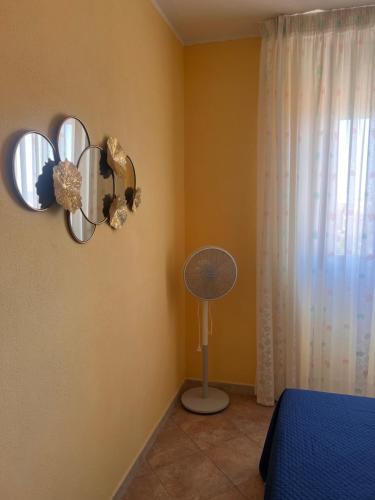 a bedroom with a bed and two mirrors and a fan at Affittacamere Cappuccini in Sassari