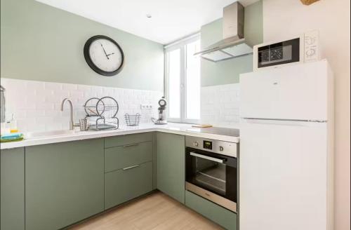 Il comprend une cuisine équipée d'un réfrigérateur et d'une horloge murale. dans l'établissement TCHOMe, à La Celle-sous-Gouzon