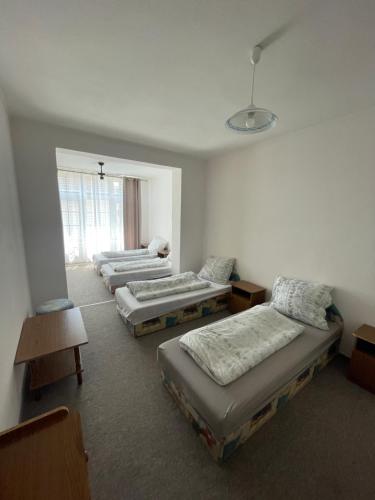 a room with three beds and a window at Tabán Vendégház in Balatonlelle