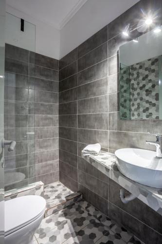 a bathroom with a sink and a toilet and a mirror at Akrotiri apartment in Pefkochori