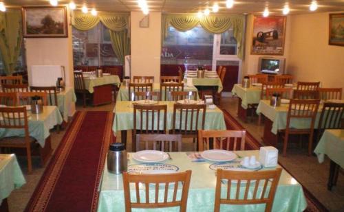 a dining room filled with tables and chairs with at Hekimoğlu Hotel in Erzurum