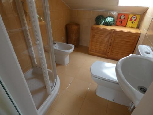 a bathroom with a toilet and a shower and a sink at Chalet Playa Portonovo in Sanxenxo