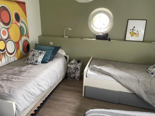 une chambre avec deux lits et une fenêtre dans l'établissement Moment de detente, à Cuy