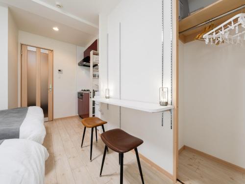 a bedroom with a bed and two stools in it at Ikebukuro 10min walk, Shinjuku 10min, Switch, Free Wi-Fi ,PocketWi-Fi in Tokyo