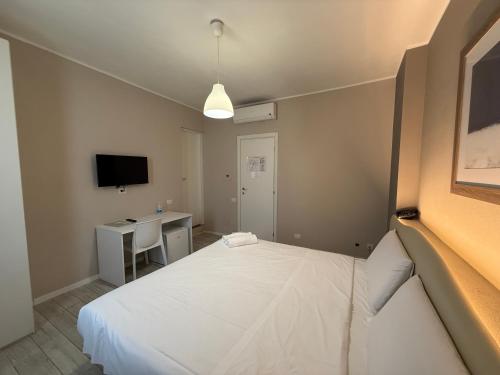 a bedroom with a bed and a desk and a television at La Bergamina Hotel & Restaurant in Arcore