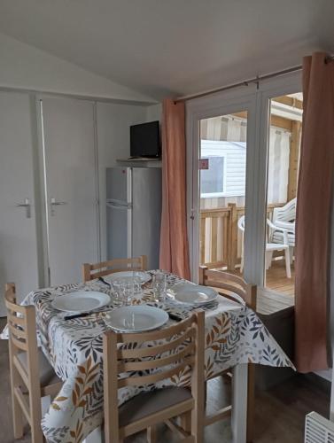 une table de salle à manger avec une nappe dessus dans l'établissement Mobilhome L'abri Côtier, à Saint-Jean-de-Monts