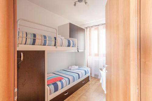 a small bedroom with two bunk beds and a window at La Breva - Terrazzo panoramico vista lago di Como in Dorio