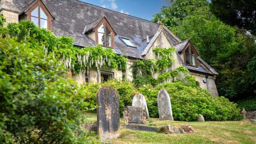 an old stone house with graves in front of it at The Old Chapel in Painswick