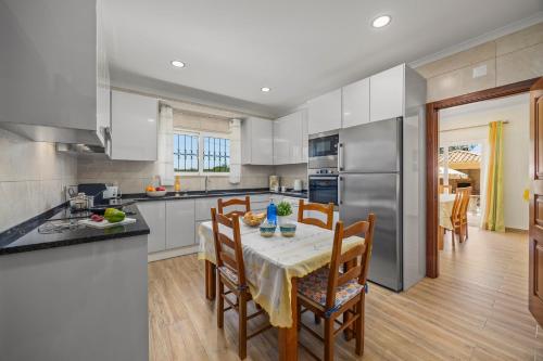 a kitchen with a table and chairs in a kitchen at Villa Monte Velho in Albufeira