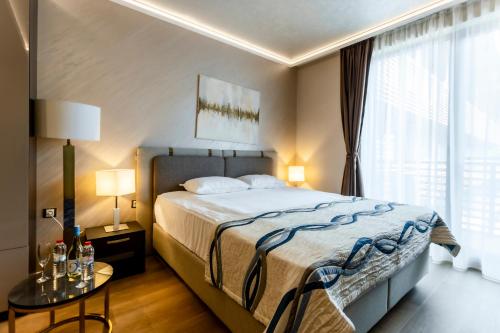 a bedroom with a bed and a large window at Galeon Residence & SPA in Sunny Beach