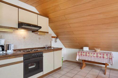 a kitchen with a stove and a table in it at Haus Marianne Dörflinger in Schluchsee