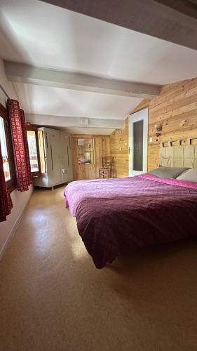 une chambre avec un grand lit dans une pièce dans l'établissement La Faucille 3, à Praranger