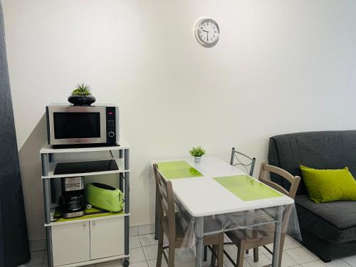 - un salon avec une table et un four micro-ondes dans l'établissement Magnan et ses plages de la Promenade des Anglais, à Nice