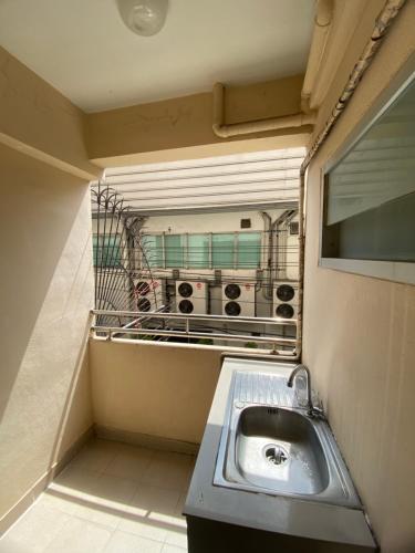 a bathroom with a sink and a mirror at Ladapan Mansion in Nonthaburi