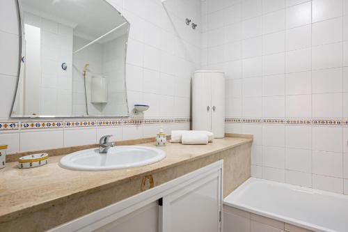un baño con lavabo y espejo en Novo Atlántico Golf, Novo Sanctipetri, en Novo Sancti Petri