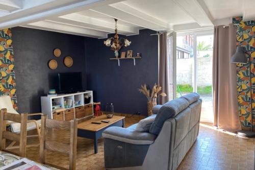 a living room with a couch and a table at Peaceful house with private outdoor space in Le Vivier-sur-Mer