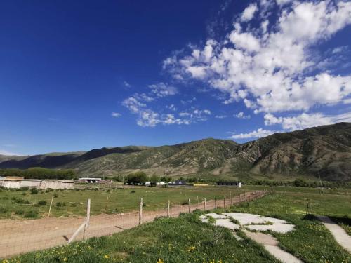 a field with a fence and mountains in the background at Гулниза 1 in Saty