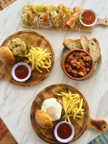 a table topped with plates of food with bread and dips at Reside Siargao in General Luna