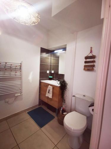 une salle de bain avec des toilettes blanches et un lavabo dans l'établissement Le Mimi'Zen, à Mimizan