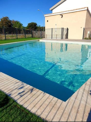 une piscine avec de l'eau bleue devant une maison dans l'établissement Le Mimi'Zen, à Mimizan